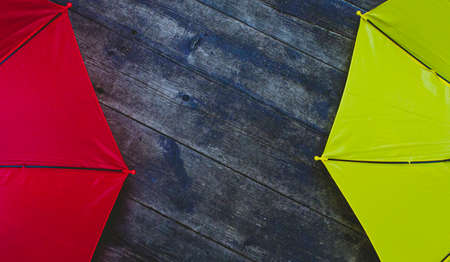 Two umbrellas red and yellow on a wooden background top view. Space for text, copy spaceの写真素材