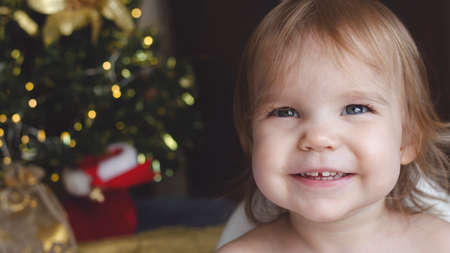 Adorable kid boy playing with cars and toys at home, indoor. funny child having fun with gifts. Colorful christmas lights on background. Family, holiday, kids lifestyle concept.の写真素材