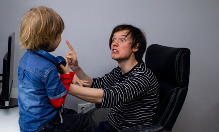 Young father scolds dad and rudely grabs the little kid son. Child abuse in education. Domestic...