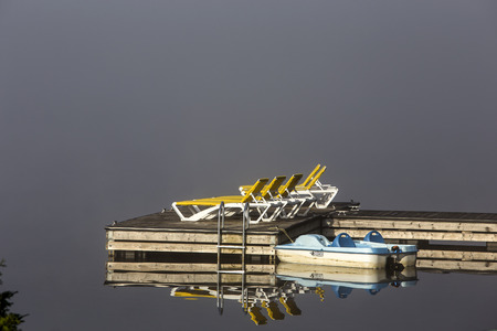 view of a boat dock the Lac-Superieur, misty morning with fog, in Laurentides, Mont-tremblant, Quebec, Canadaの写真素材