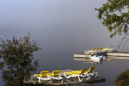 view of a boat dock the Lac-Superieur, misty morning with fog, in Laurentides, Mont-tremblant, Quebec, Canadaの写真素材