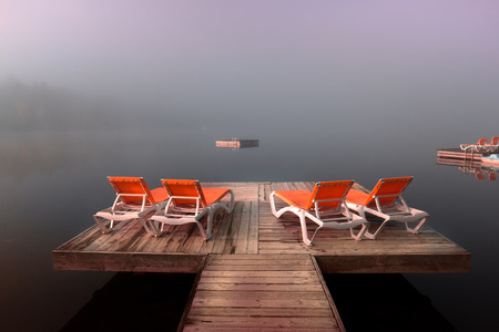 view of a boat dock the Lac-Superieur, misty morning with fog, in Laurentides, Mont-tremblant, Quebec, Canadaの写真素材