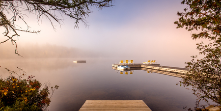 view of a boat dock the Lac-Superieur, misty morning with fog, in Laurentides, Mont-tremblant, Quebec, Canadaの写真素材