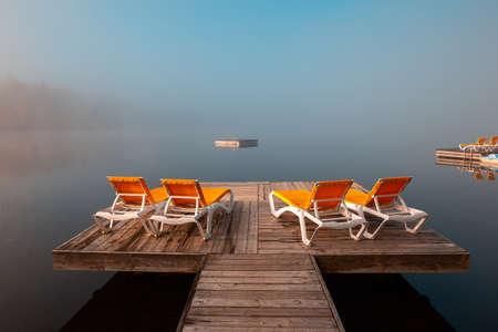 view of a boat dock the Lac-Superieur, misty morning with fog, in Laurentides, Mont-tremblant, Quebec, Canadaの写真素材