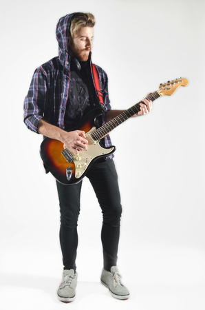 Young man playing the guitar on isolated white backgroundの写真素材