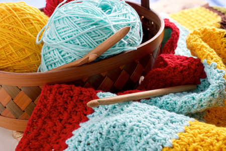 Ball of yarn in basket on wood table