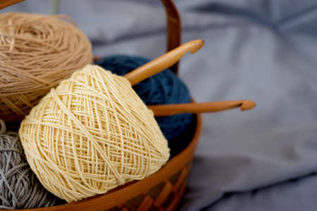 Ball of yarn beige tone in basket on fabricの写真素材