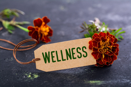 Natural looking label with wellness text and red flowers on black grunge backgroundの写真素材