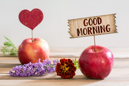 good morning wooden sign pined an apple with flower around and red heart shape on wood deskの写真素材