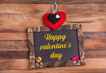 Happy valentine's day written on wooden frame with heartの写真素材