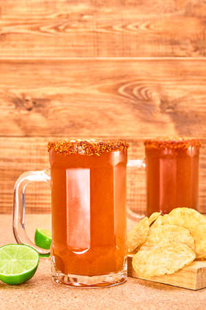 Mexican style beer mug (Chelada / Michelada) with lime, hot sauce and chamoy, frosted with chili...