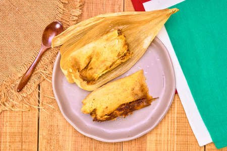 tamal de mole poblano (mole poblano tamale) with pork on a brown plate. top view. traditional mexican food.の写真素材