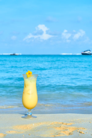 piÃ±a colada on the sand on the beaches of Cancun, Mexico. sea background out of focus with yachts. copy space for advertising. close up view.の写真素材
