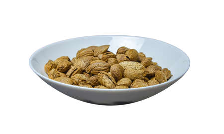 roasted almonds in peel on a plate on a white layerの写真素材