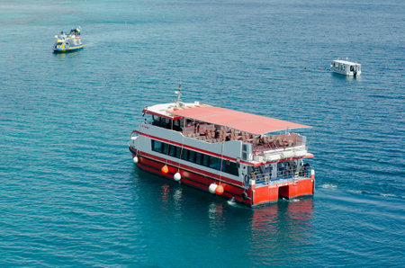 A red and white pleasure boat sails in the Red Sea during the day near the coast of Eilat in Israel on March 12 2021のeditorial素材
