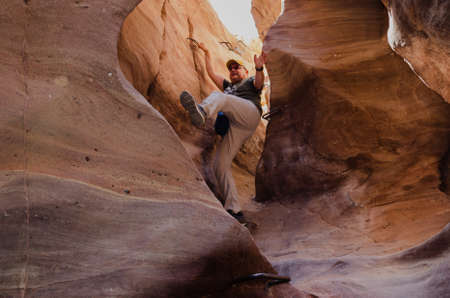 fat man descends into a narrow crevice in the mountains