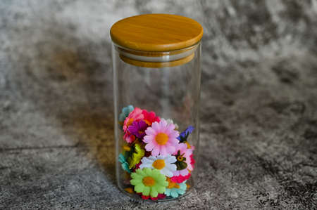 decorative elements for various festive events are placed in glass jars on a light backgroundの写真素材