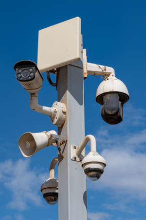 Group of cctv cameras and speaker on metal pole in the street close up
