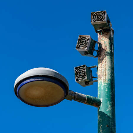 Lamp post with loudspeakers against blue sky close upの写真素材