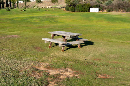 Picnic table on green meadow in amusement parkの写真素材
