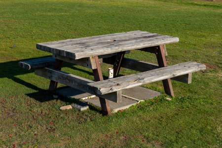 Picnic table on green meadow in amusement parkの写真素材