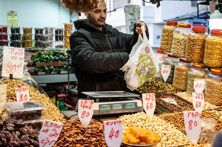 TEL AVIV, ISR - January 25, 2022: Israelis shop at the Carmel Shuk HaCarmel Market in Tel Aviv, Israel. This is a very popular market in Tel Aviv where they sell confectionery as well as fruits and vegetables.のeditorial素材