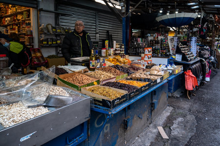TEL AVIV, ISR - January 25, 2022: Israelis shop at the Carmel Shuk HaCarmel Market in Tel Aviv, Israel. This is a very popular market in Tel Aviv where they sell confectionery as well as fruits and vegetables.のeditorial素材