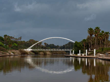 An arc bridge over the river in a recreation and amusement park. In the water you can see the...