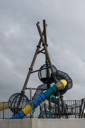 The outdoor playground is equipped with slides and equipment for climbing and physical development of children. In the recreation and entertainment park.の写真素材