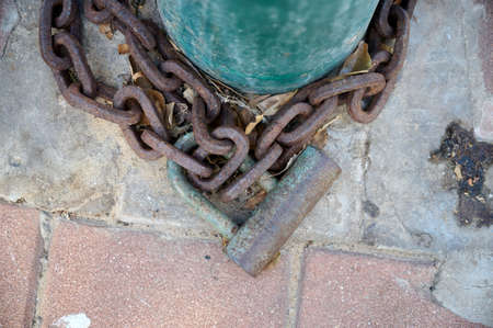 Closeup wooden door on the private road,locked with a chain and a rusty padlock. close-upの写真素材