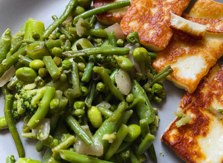 Grilled halloumi cheese on a plate with green beans. close-up.