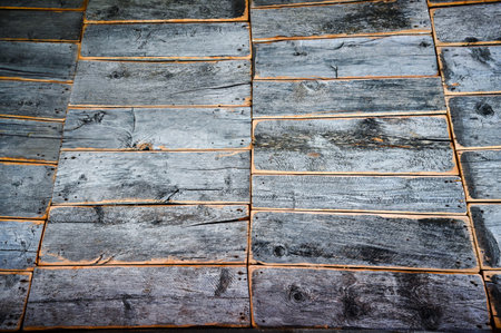 Old, worn, gray wooden, vertical boards. Some pieces of the wood are missing. close-up texture