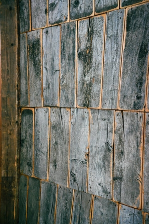 Old, worn, gray wooden, vertical boards. Some pieces of the wood are missing. close-up textureの写真素材