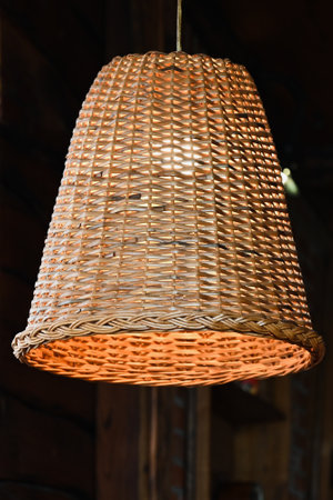 three rattan chandeliers different forms on white brick wall background. Straw lampshade in cozy...