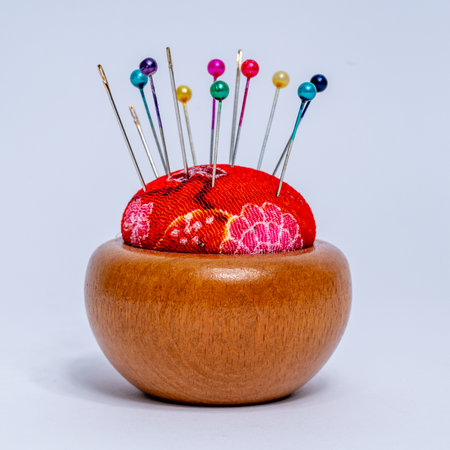 Sewing pins and needle cases on wooden stand isolated on white background. High quality photoの写真素材