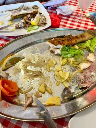 fish scraps on plates after eating on the table. High quality photoの写真素材