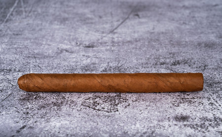 A cigar made of tobacco leaves lies on a gray marble table. High quality photoの写真素材
