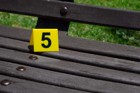 One yellow crime scene marker on a wooden bench. High quality photoの写真素材