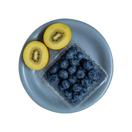 Fresh blueberries and kiwi halves on a blue plate on a white background. High quality photoの写真素材