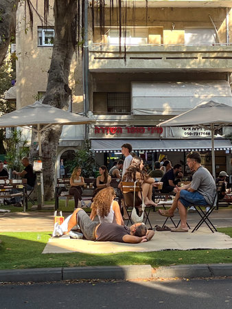 Tel Aviv, Israel, November 21, 2025: Visitors are sitting on outdoor carpets near a cafe in the Hatsafon Hayashan - South Part area. High quality photoのeditorial素材