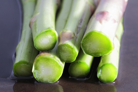 wild asparagus in various situations of their preparation in the kitchen macro imagesの写真素材