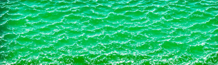 Green water surface background with transparent ripples and minty texture, representing skincare and...