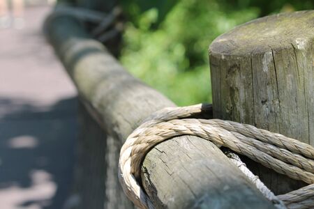 rope tied on pole fence foreground focusの写真素材