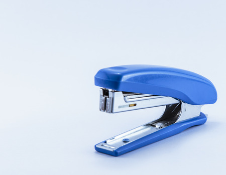 an office stapler with blue handgrip isolated on white backgroundの写真素材
