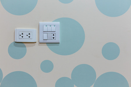 power outlet and light switch on the abstract wall