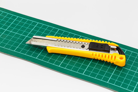 Yellow Knife Paper Cutter on cutting mat isolated on a white background.の写真素材