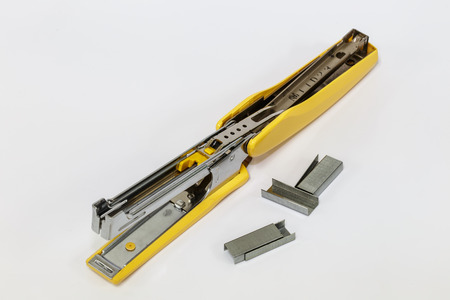 Yellow Stapler with staples on a white background