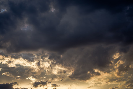 Stormy weather with dark clouds over blue sky at sunset