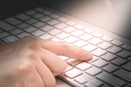 Housewife doing online banking, online shopping, making a payment or purchasing goods on the internet entering her credit card details on a pc, close up view of her hands.の写真素材