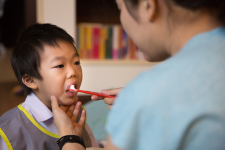 Mother teaching little boy to brush his teethの写真素材
